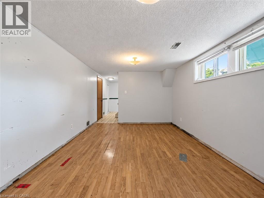 Wood-finish flooring with white walls and a white textured ceiling - 2490 Yarmouth Crescent, Oakville, ON
