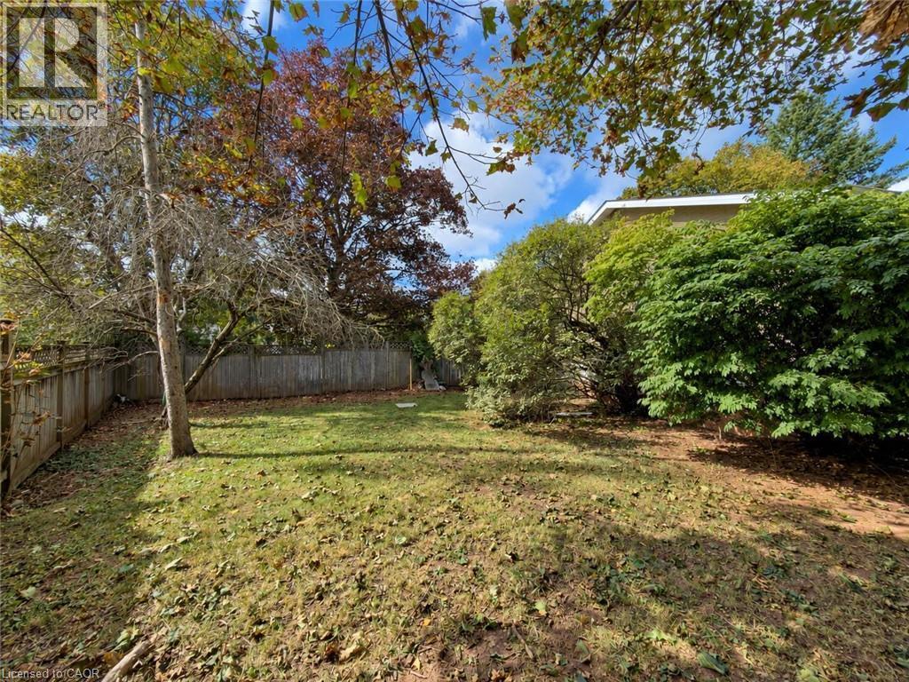Expansive backyard featuring a mature tree, perimeter fencing, and established shrubbery - 2490 Yarmouth Crescent, Oakville, ON