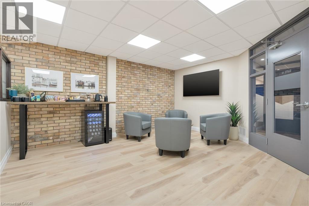 Light wood-finish flooring with exposed brick accent walls - 23 Market Street W, Port Dover, ON
