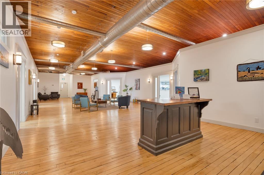 Wood-finish flooring, exposed wood-finish ceiling, exposed metal ductwork, recessed lighting, and wall-mounted sconces - 23 Market Street W, Port Dover, ON