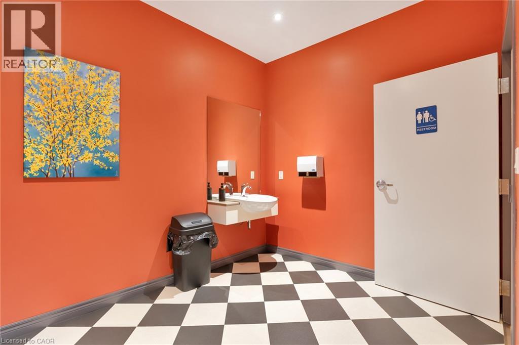 Wall-mounted vanity with a rectangular basin, chrome faucet, and integrated mirror - 23 Market Street W, Port Dover, ON