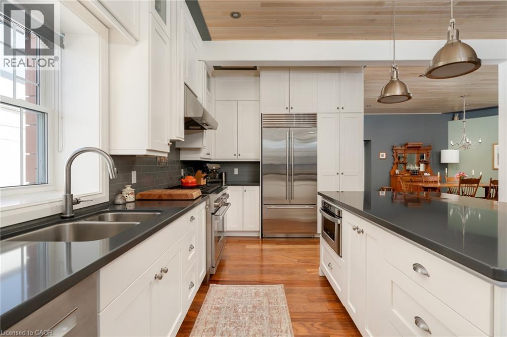 Gourmet kitchen featuring stainless steel appliances, dark countertops, white cabinetry, and a hardwood ceiling - 23 Market Street W, Port Dover, ON