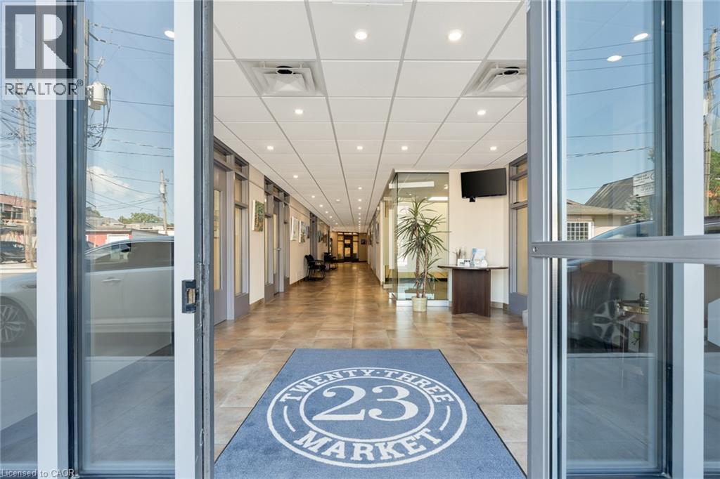 Spacious entry corridor with tiled flooring, recessed lighting, drop ceiling, and glass-paneled entry doors - 23 Market Street W, Port Dover, ON