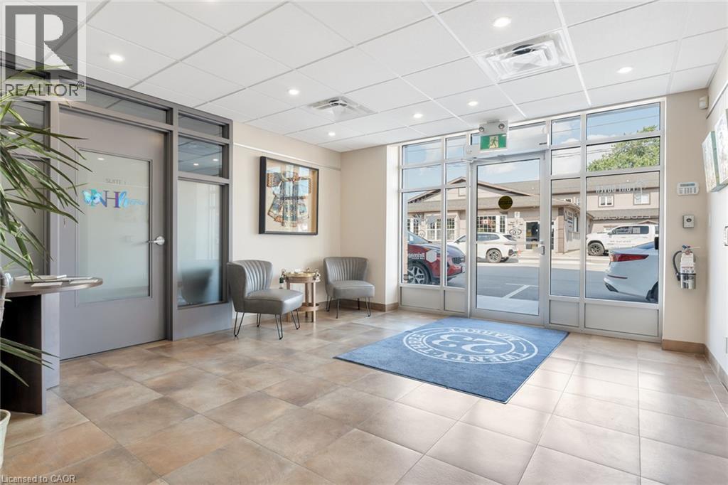Tiled flooring, recessed lighting, expansive glass storefront, and an interior glass-paneled entry door - 23 Market Street W, Port Dover, ON