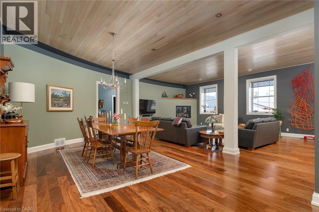 Hardwood flooring extends throughout the space, complemented by a wood-paneled ceiling - 23 Market Street W, Port Dover, ON