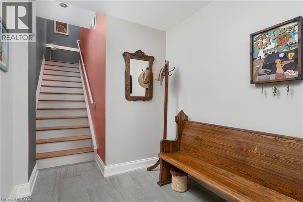 Staircase with wood treads and white risers, grey tile flooring, and recessed ceiling lighting - 23 Market Street W, Port Dover, ON