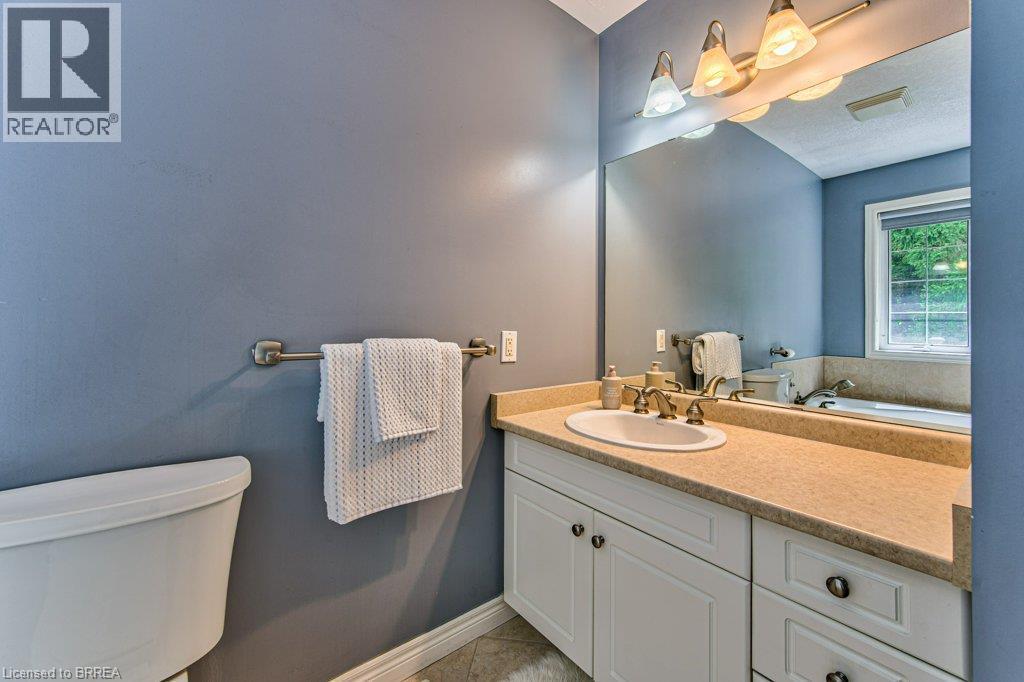 White vanity with cabinet storage, integrated sink, and bronze-finish faucet - 423 Poldon Drive, Norwich, ON
