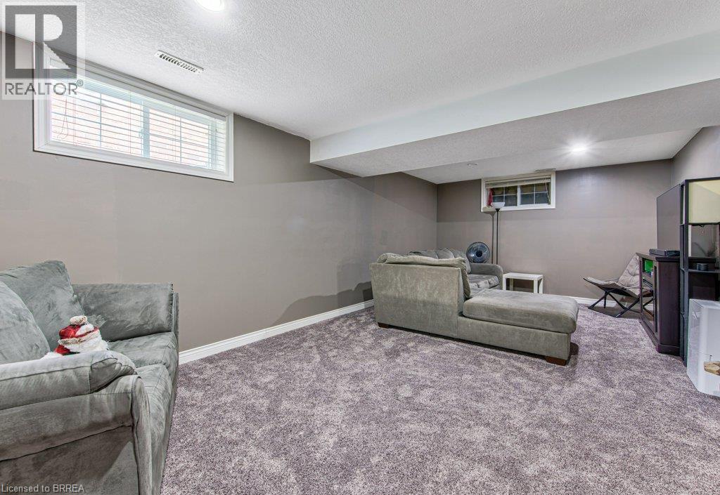 Recessed lighting illuminates a spacious room featuring wall-to-wall carpeting and neutral gray walls - 423 Poldon Drive, Norwich, ON