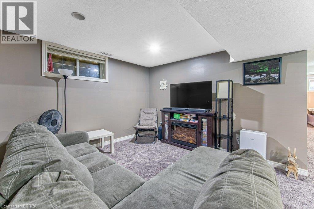 Carpeted entertainment area with recessed lighting, a built-in media console, and a window - 423 Poldon Drive, Norwich, ON