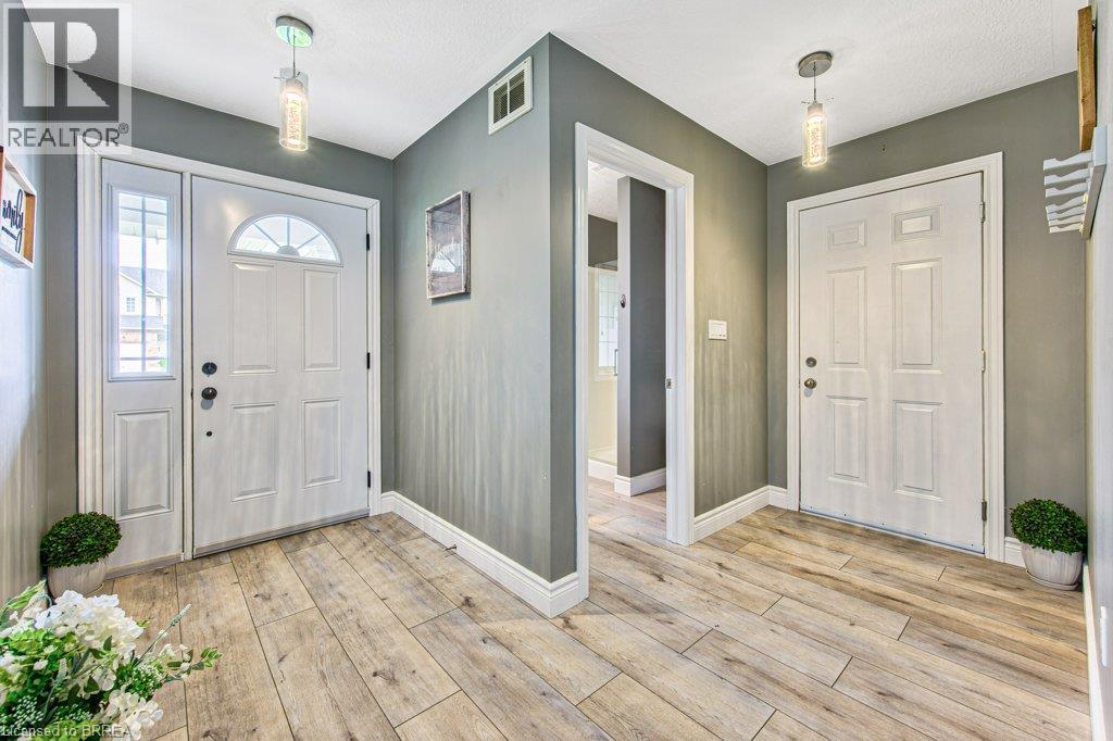 Wood-finish flooring, white trim, recessed lighting, and a white paneled door with an arched transom - 423 Poldon Drive, Norwich, ON