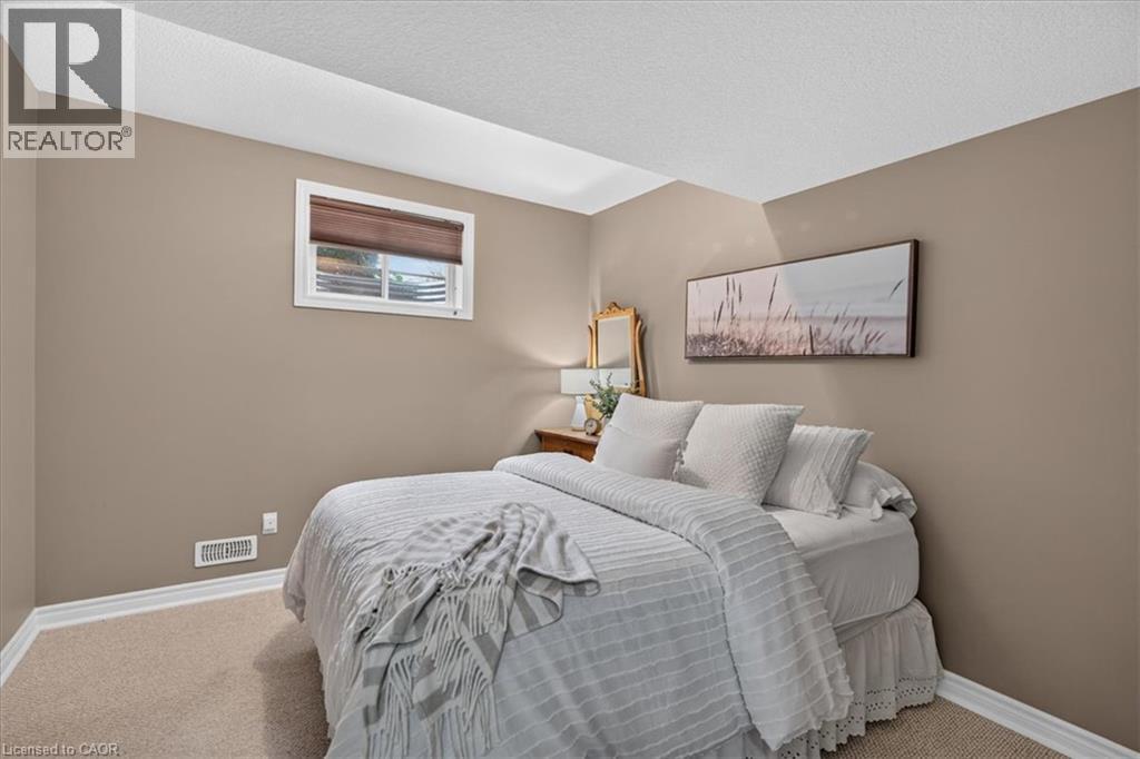 Carpeted flooring, neutral wall tones, window with roller shade, and white trim accents - 515 Woodward Drive, Mount Brydges, ON