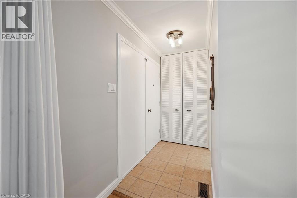 Tiled flooring, crown molding, white louvered closet doors, and flush mount lighting - 35 Crosby Drive, Kitchener, ON