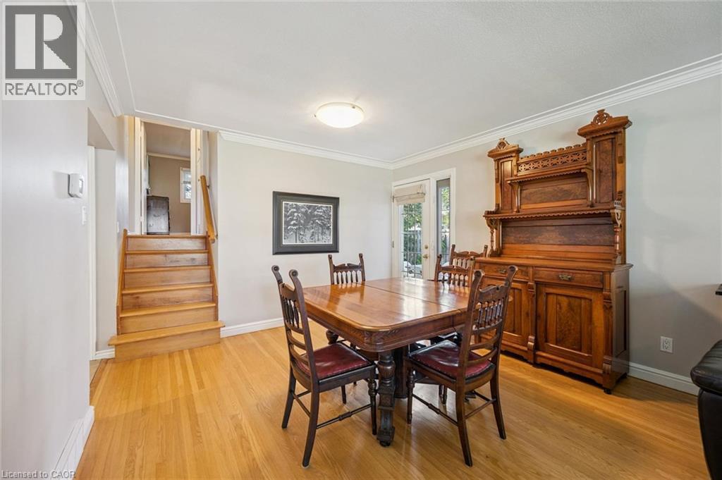 Hardwood flooring, light gray wall tones, crown molding, a built-in staircase, and a rear door with an exterior view - 35 Crosby Drive, Kitchener, ON