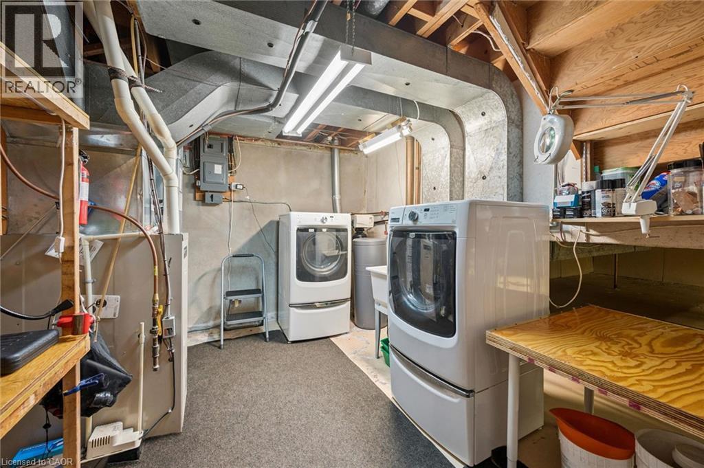Utility room featuring a built-in shelf, exposed ductwork, concrete walls, and overhead lighting - 35 Crosby Drive, Kitchener, ON