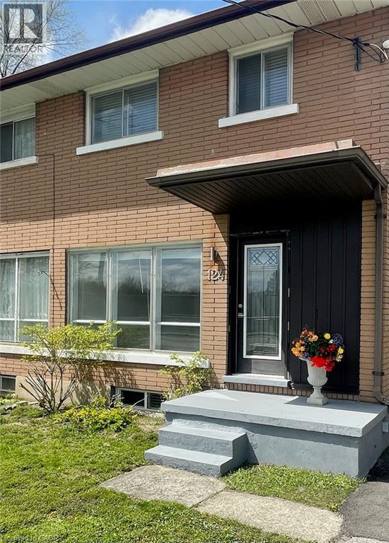 Brick facade featuring a covered entry with a glass-paneled door, concrete steps, and a bay window - 124 Avalon Place, Kitchener, ON