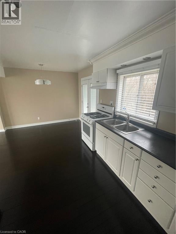 Kitchen with gas range, hanging light fixtures, white cabinetry - 124 Avalon Place, Kitchener, ON