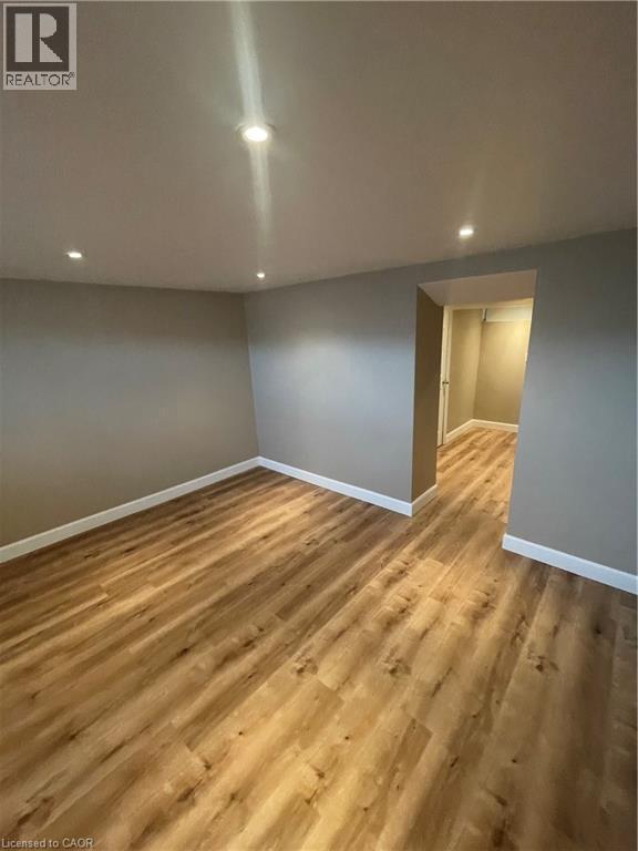 Recreation room featuring new light wood-type flooring and recessed lighting - 124 Avalon Place, Kitchener, ON