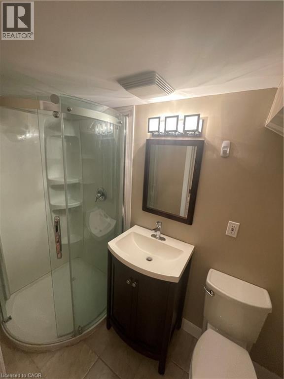 Bathroom featuring vanity, shower stall, and light tile patterned floors - 124 Avalon Place, Kitchener, ON