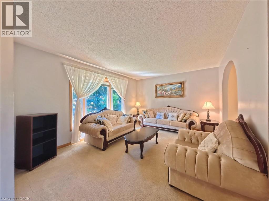 Arched entryway, window with wood trim, wall-to-wall carpeting, and light-toned walls - 56 Scenic Wood Crescent, Kitchener, ON