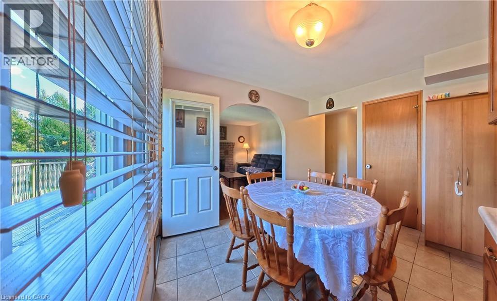 Tile flooring, arched doorway, wood-finish cabinetry, white paneled door with glass insert, and a ceiling-mounted light fixture - 56 Scenic Wood Crescent, Kitchener, ON