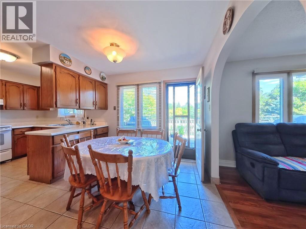 Kitchen with wood-finish cabinetry, light-toned countertops, and tile flooring - 56 Scenic Wood Crescent, Kitchener, ON