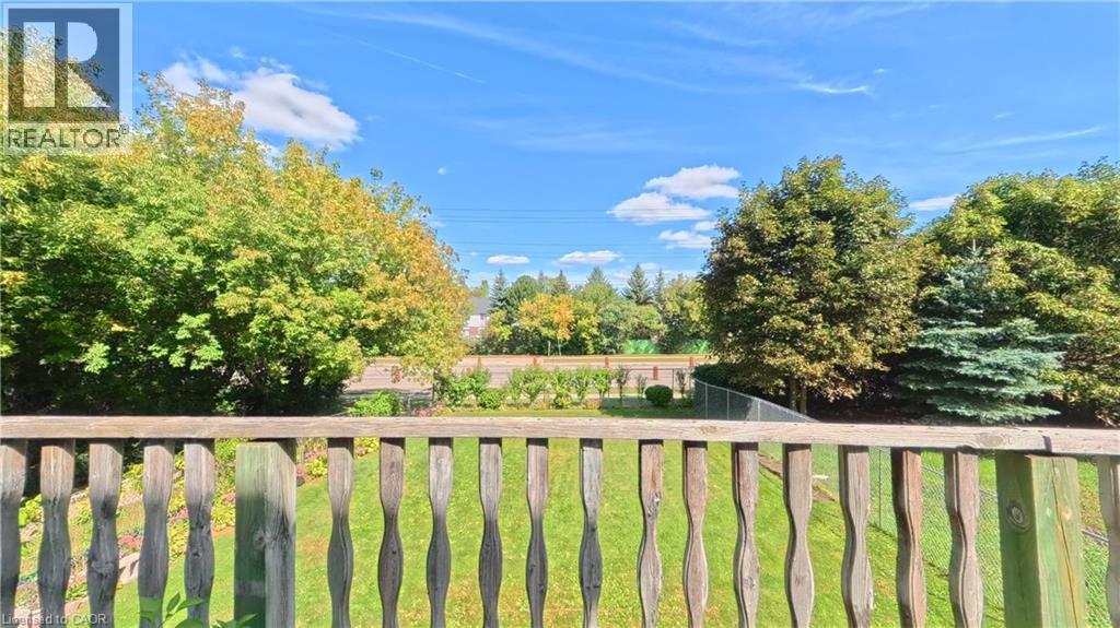 Manicured lawn with mature trees and a chain-link fence - 56 Scenic Wood Crescent, Kitchener, ON