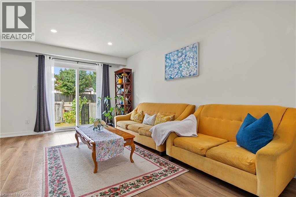 Wood-finish flooring, recessed lighting, white walls, and a sliding glass door to the backyard - 1444 Upper Ottawa Street Unit# 32, Hamilton, ON