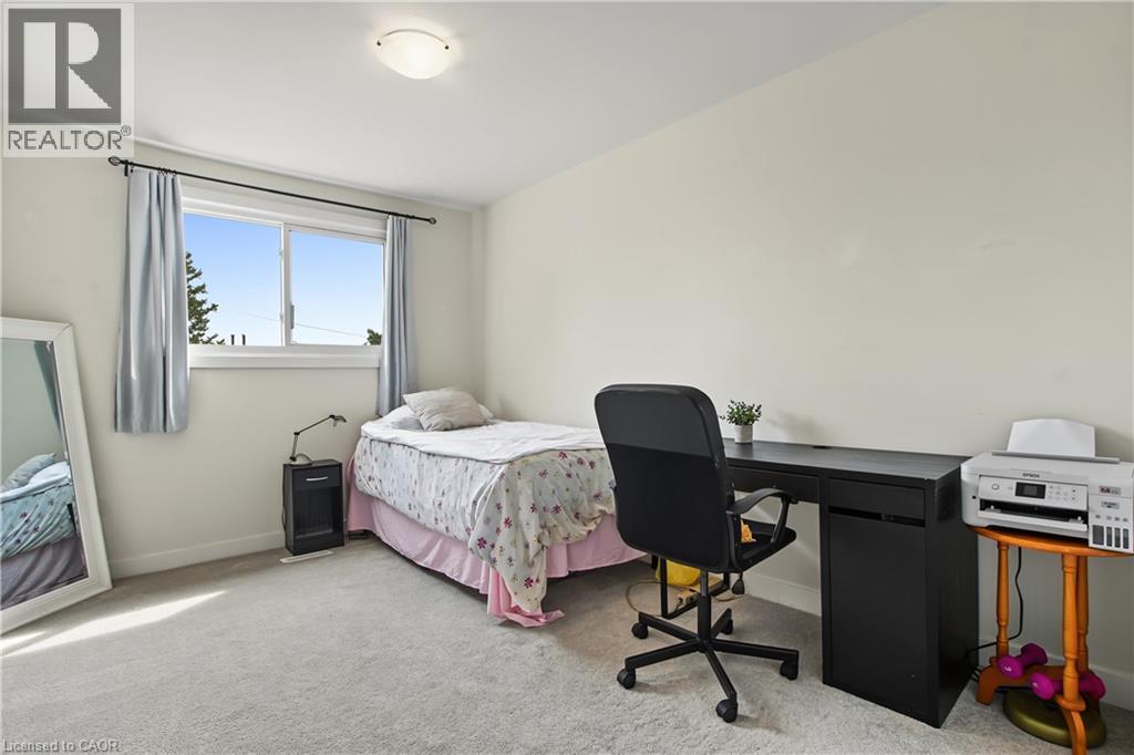 Light-colored wall finishes with a ceiling-mounted light fixture, light gray carpet flooring, and a window with a white frame - 1444 Upper Ottawa Street Unit# 32, Hamilton, ON