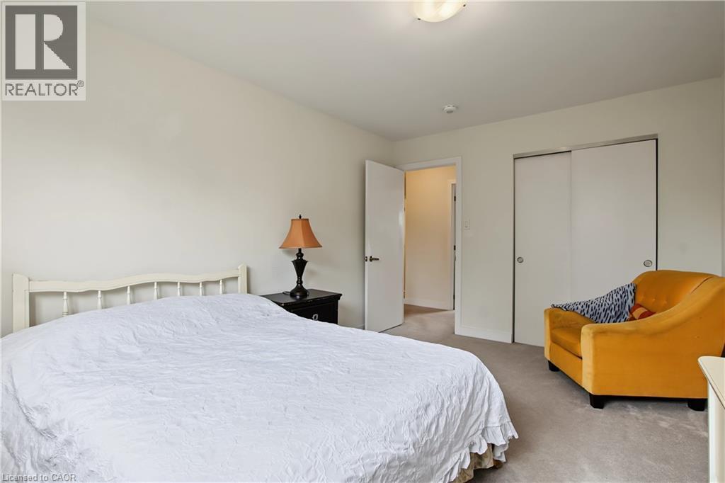 Carpeted flooring, white walls, white interior door, and built-in sliding closet doors - 1444 Upper Ottawa Street Unit# 32, Hamilton, ON