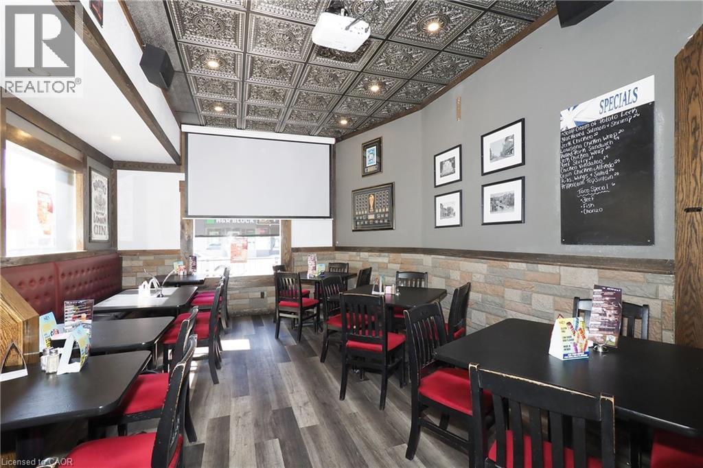 Decorative pressed-tin ceiling tiles, projector with retractable screen, wood-finish flooring, stone-veneer wall accents, and recessed lighting - 707 E King Street E, Cambridge, ON
