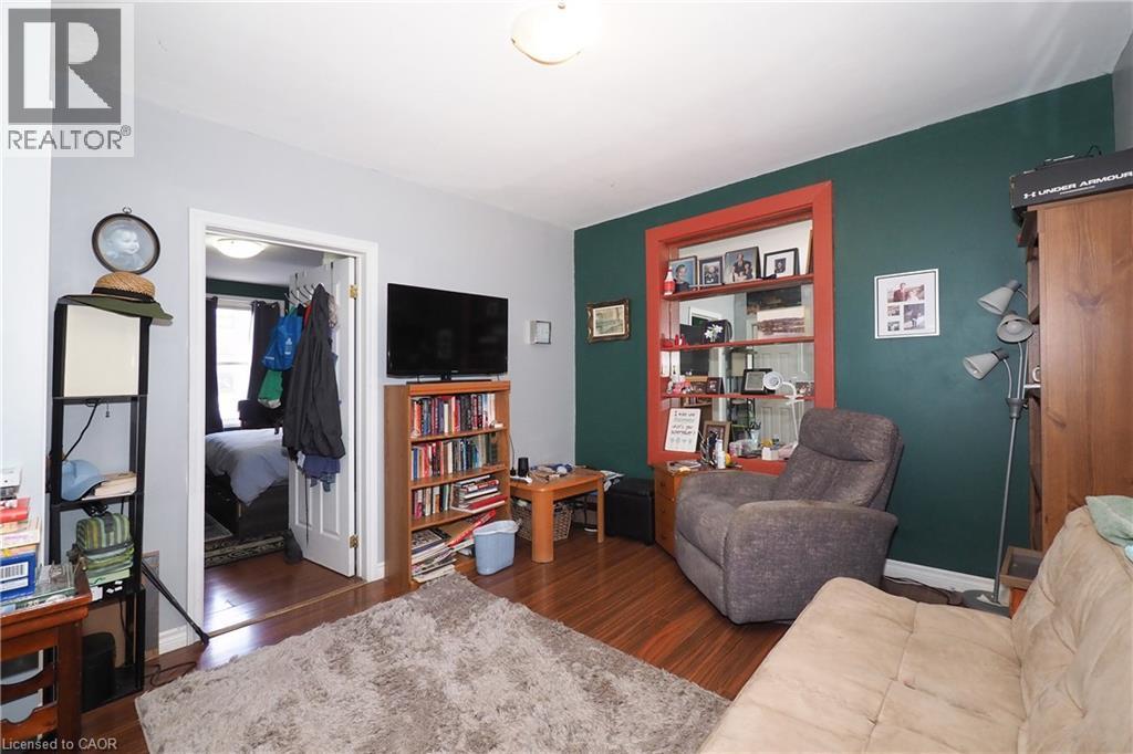 Wood-finish flooring throughout, featuring a distinctive accent wall with a contrasting trim window - 707 E King Street E, Cambridge, ON