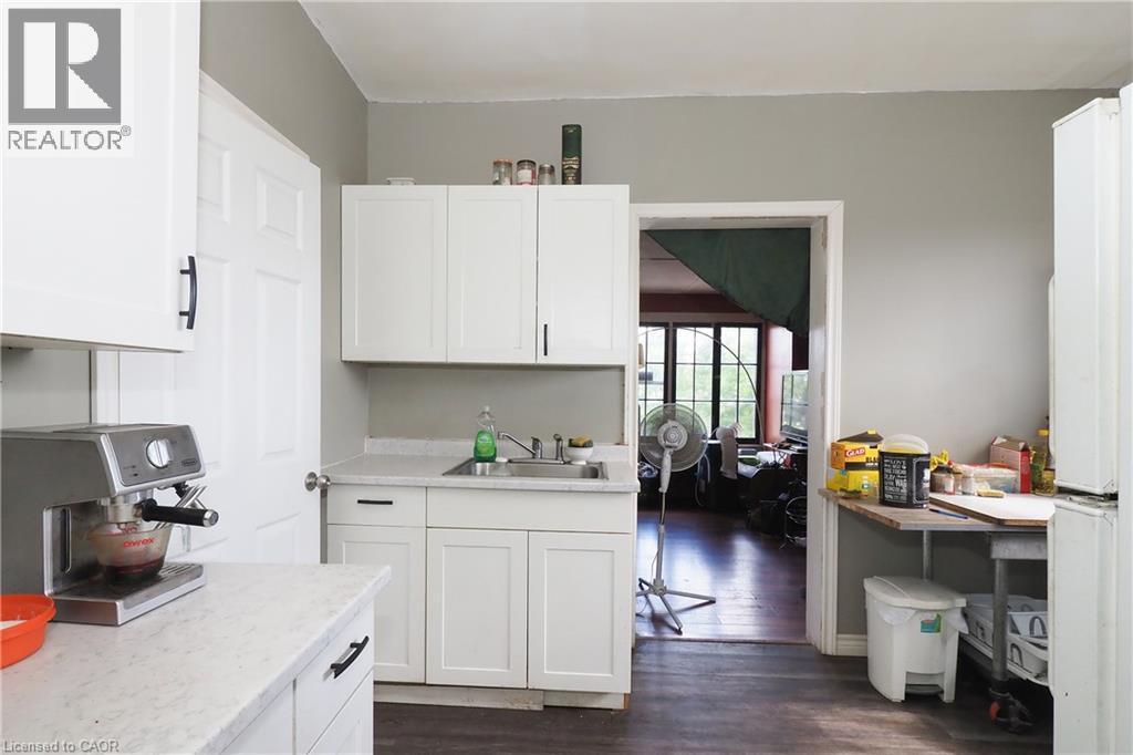 White cabinetry with black hardware, light-toned countertops, and wood-finish flooring - 707 E King Street E, Cambridge, ON