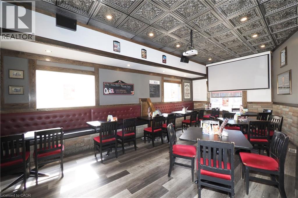 Ornate tin ceiling, recessed lighting, wood-finish flooring, built-in banquette seating, and a mounted projection screen - 707 E King Street E, Cambridge, ON