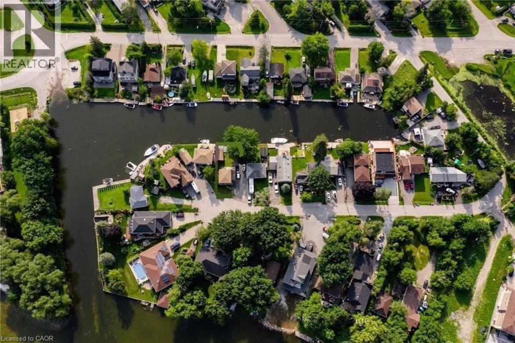 Waterfront properties with private docks, lush green landscaping, and diverse architectural styles - 35 Shirlea Boulevard, Keswick, ON