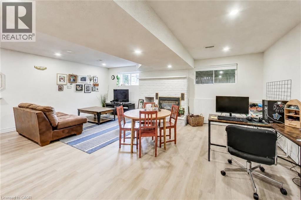 Wood-finish flooring throughout, featuring recessed lighting, a painted brick fireplace, and a built-in window - 35 Shirlea Boulevard, Keswick, ON