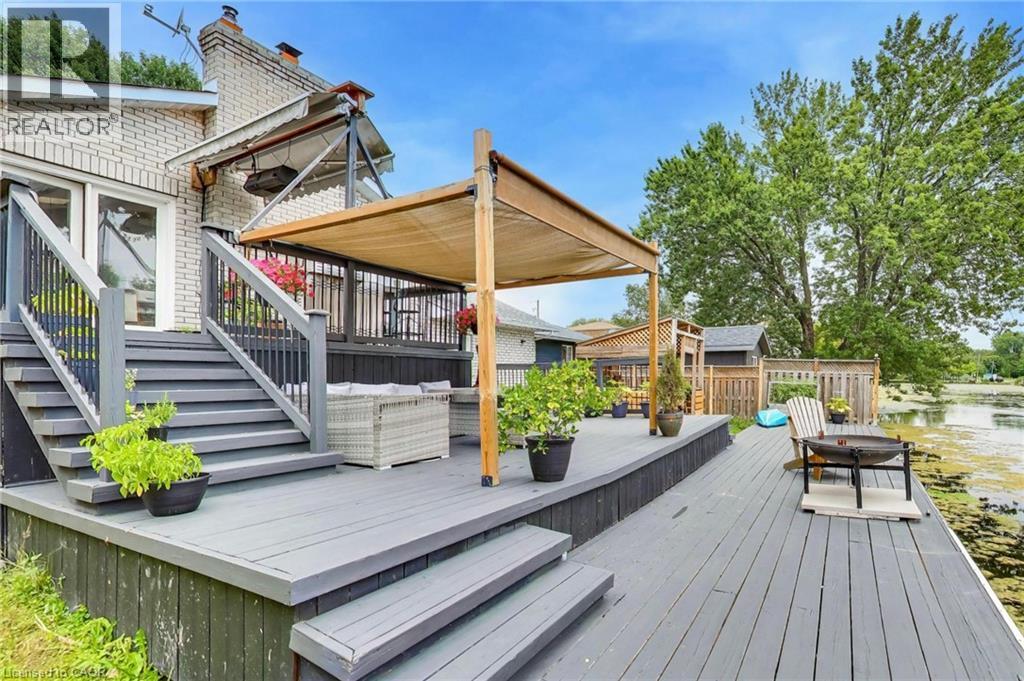 Expansive multi-level wooden deck featuring a retractable pergola and direct water access - 35 Shirlea Boulevard, Keswick, ON