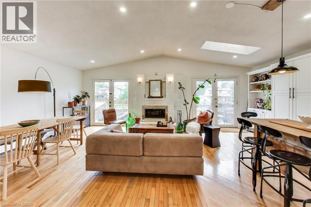 Hardwood flooring throughout, vaulted ceiling, recessed lighting, white brick fireplace, and built-in white cabinetry - 35 Shirlea Boulevard, Keswick, ON