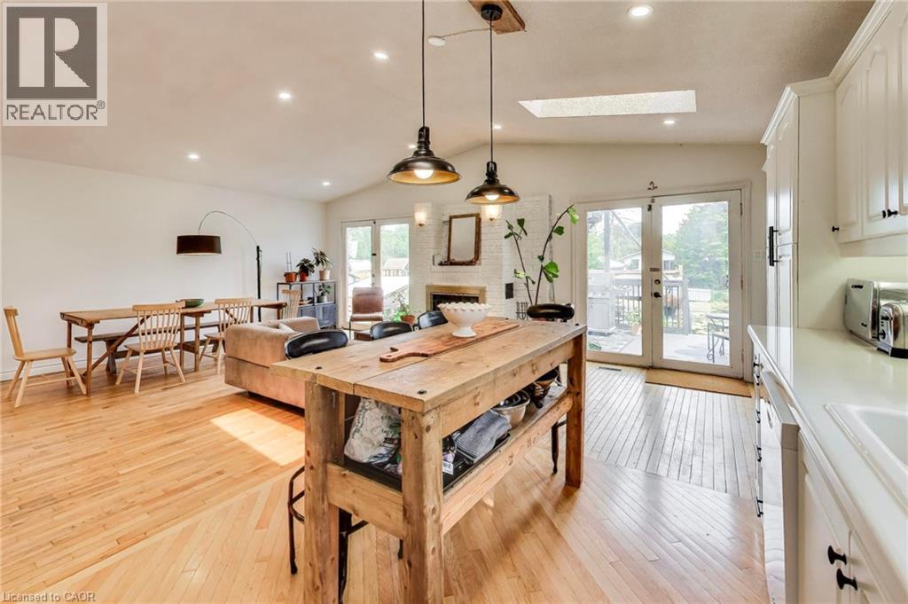 Open-concept living space featuring wood-finish flooring, recessed lighting, a skylight, and white cabinetry - 35 Shirlea Boulevard, Keswick, ON