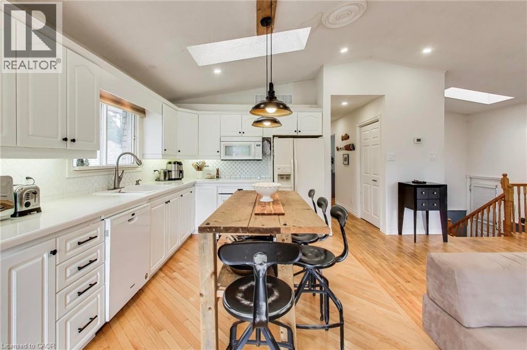 White kitchen cabinetry with black hardware, white countertops, and a white subway tile backsplash - 35 Shirlea Boulevard, Keswick, ON