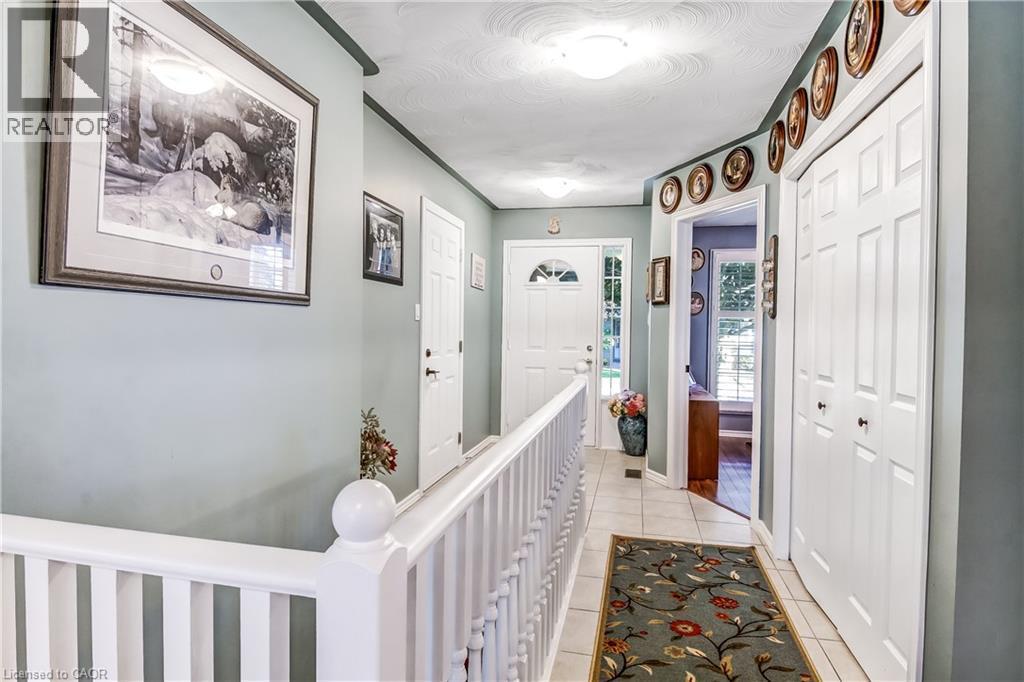 Foyer featuring tile flooring, white railings, and a white paneled door with a transom window - 150 Oak Street Unit# 27, Simcoe, ON