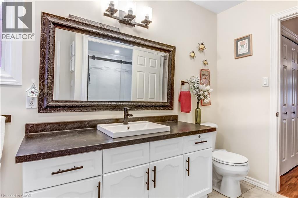 White vanity with dark hardware, vessel sink with dark-finish faucet, and a dark-finish countertop - 150 Oak Street Unit# 27, Simcoe, ON