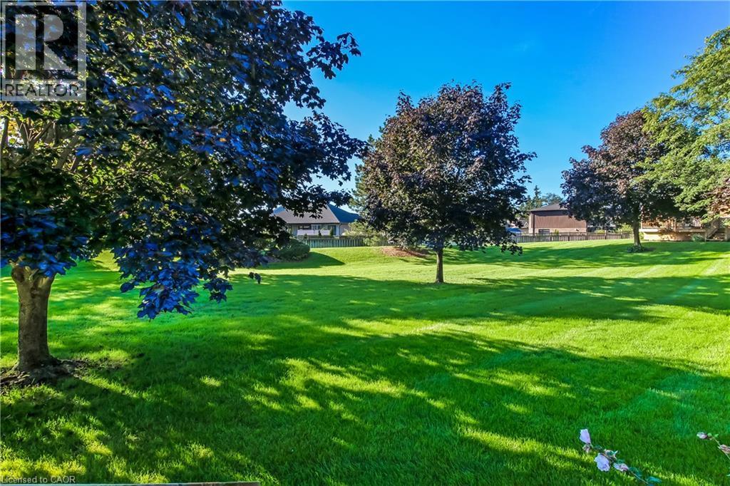 Expansive green lawn, always well maintained with mature trees. - 150 Oak Street Unit# 27, Simcoe, ON