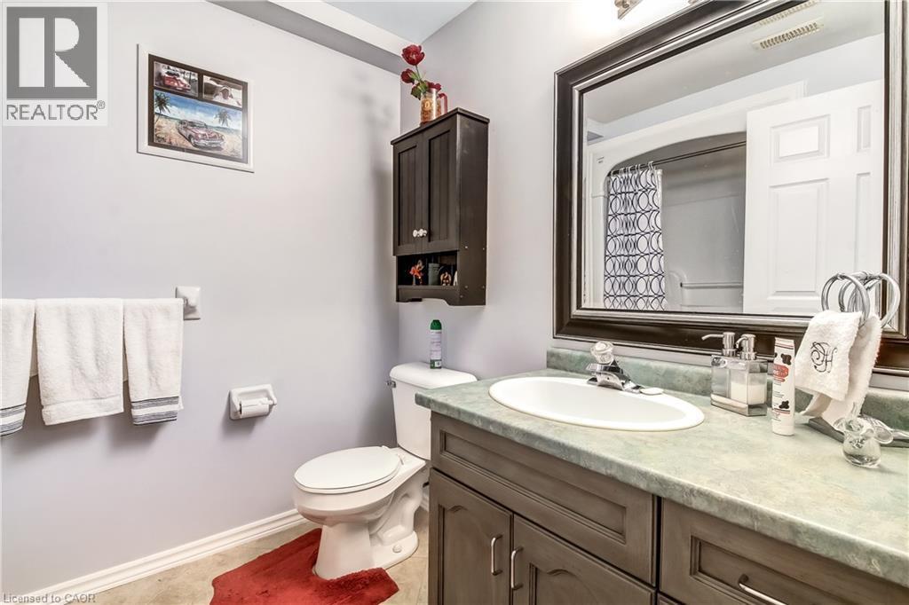 Vanity with an integrated sink, a large framed mirror, and a wall-mounted cabinet - 150 Oak Street Unit# 27, Simcoe, ON