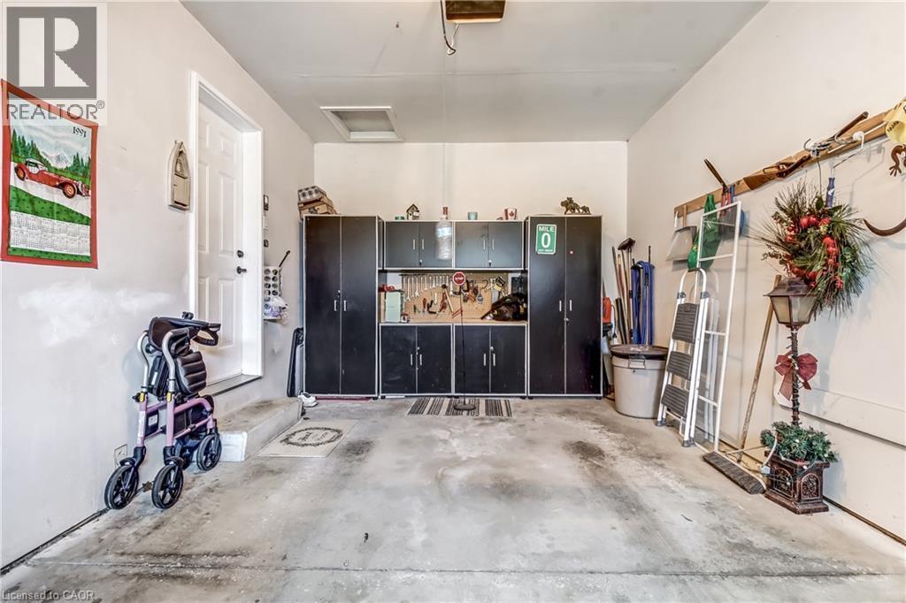 Single car garage with black cabinets for extra storage. - 150 Oak Street Unit# 27, Simcoe, ON