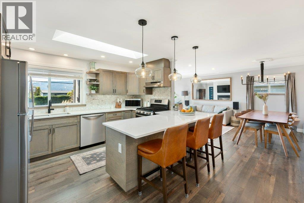 Kitchen with skylight and many updates: quartz counters, backsplash, appliances, lighting - 886 Fairview Road, Oliver, BC