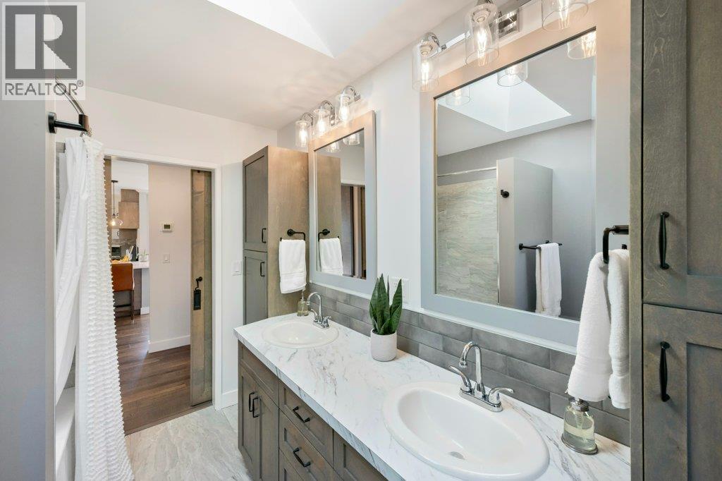 Main bath with dual vanities, tiled tub/shower surround - 886 Fairview Road, Oliver, BC
