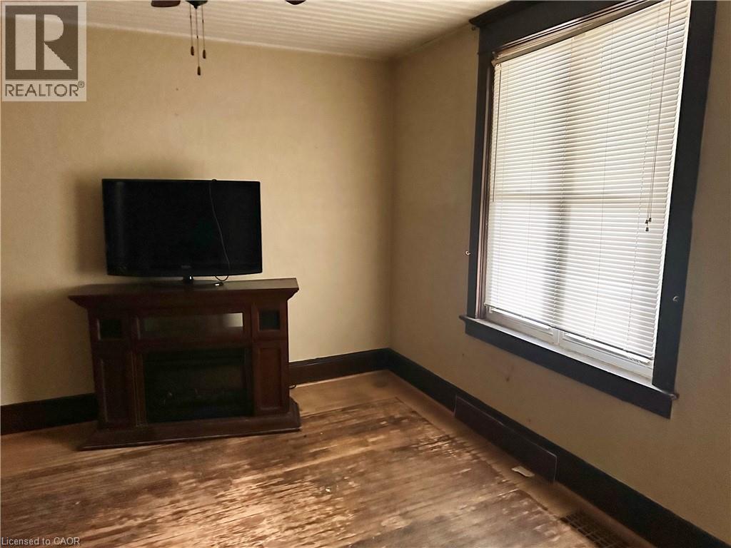 dark wood surround, window with white blinds, and a ceiling fan - 128 Kent Street S, Simcoe, ON