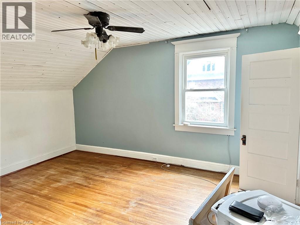 Bedroom - Wood-finish flooring with a sloped ceiling and wood paneling - 128 Kent Street S, Simcoe, ON