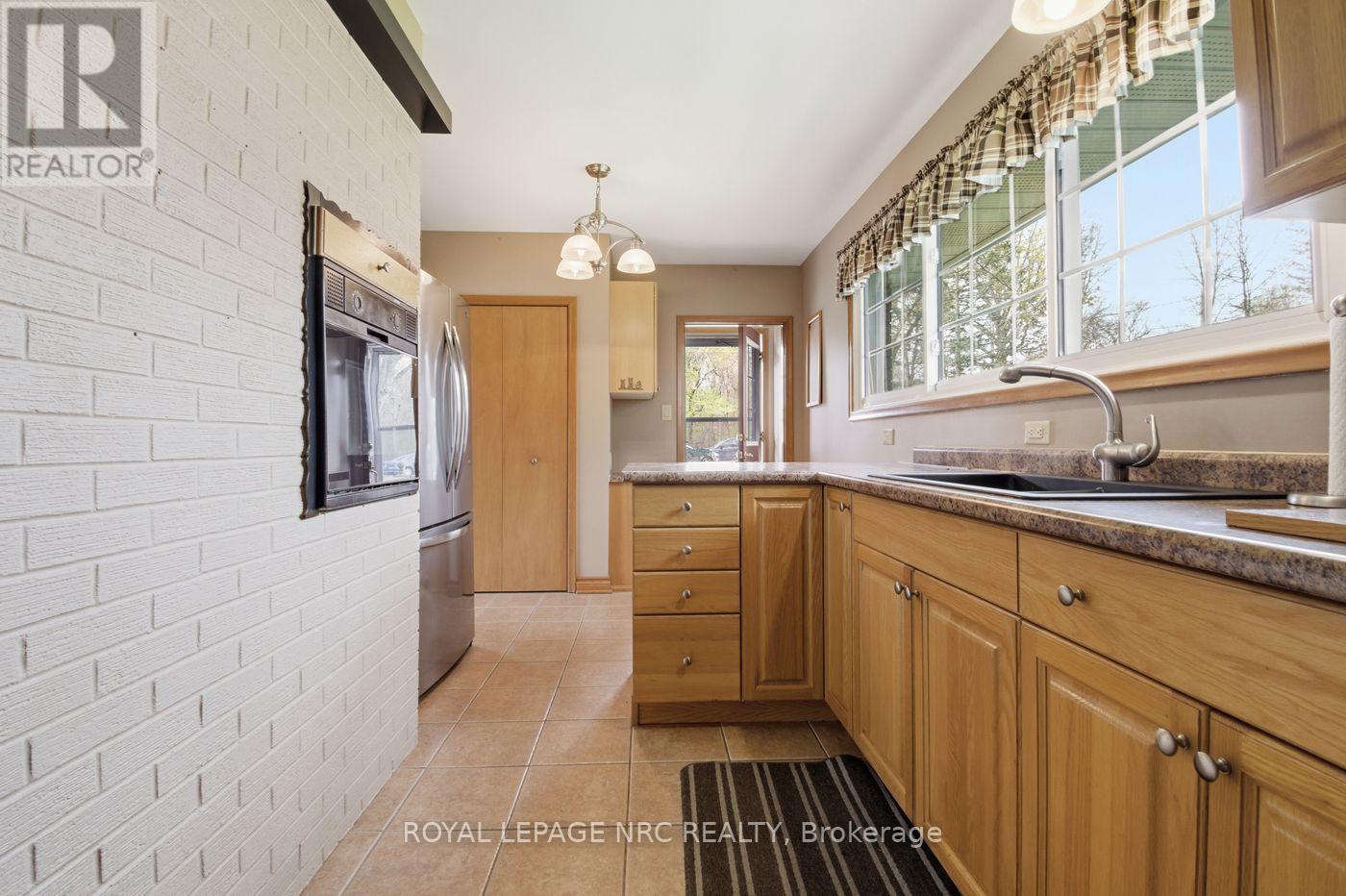 galley style kitchen view to side door and pantry - 53 Pearson Road, Welland (Cooks Mills), ON