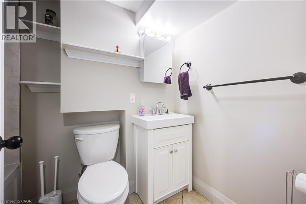 White vanity with a rectangular basin sink, chrome faucet, and storage cabinet - 2037 Mountain Grove Avenue, Burlington, ON